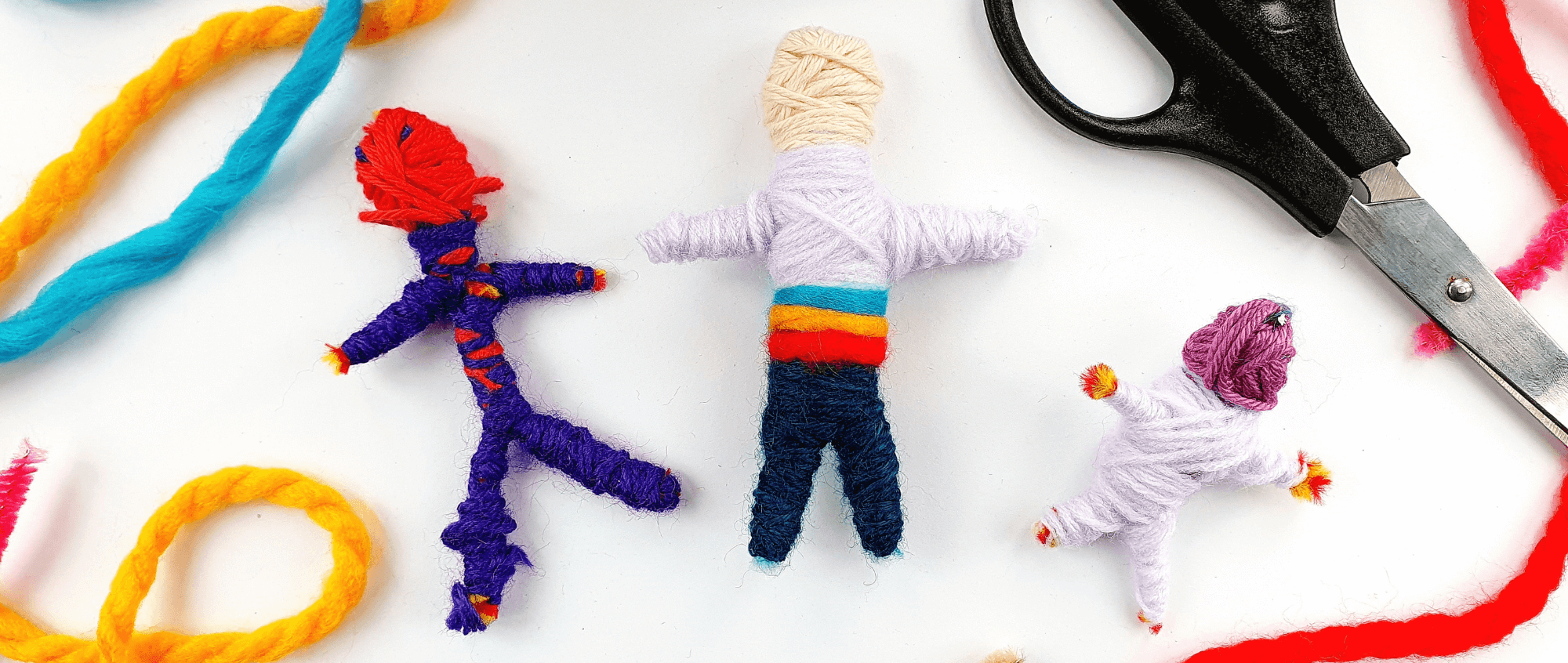 Small figures made from colourful wool on a white background. Image ©HanaSharkey.