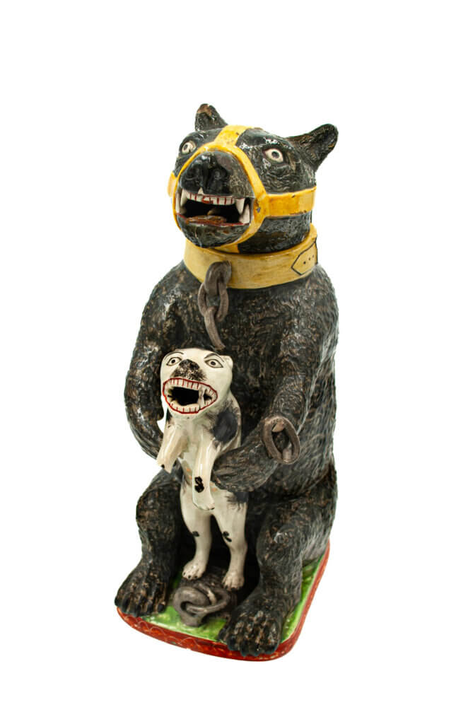 A jug shaped like a muzzled black bear holding a baby bear in its hands.