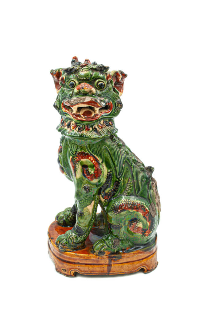 A green and red glazed Chinese statue of a lion.