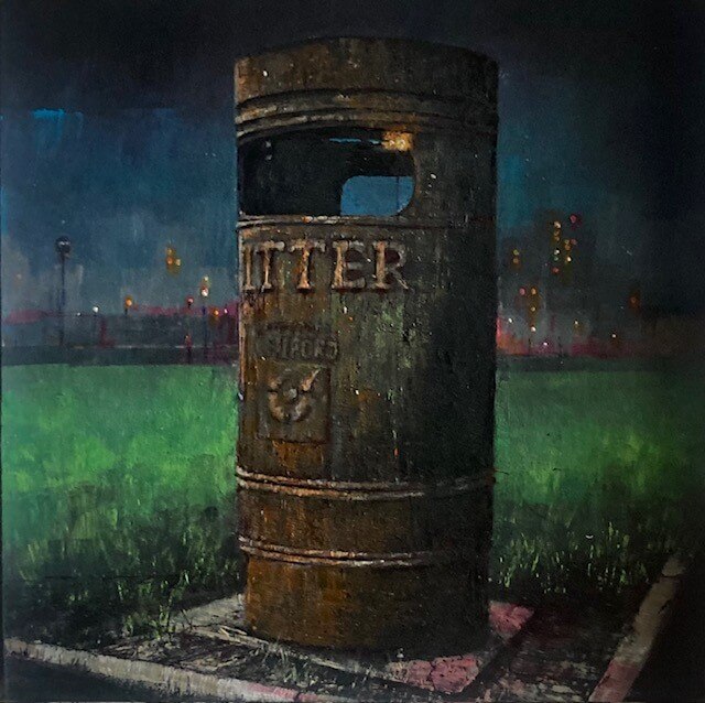 A black bin with the word 'LITTER' written on it. In the background there is a cityscape with lights glowing in the dark.