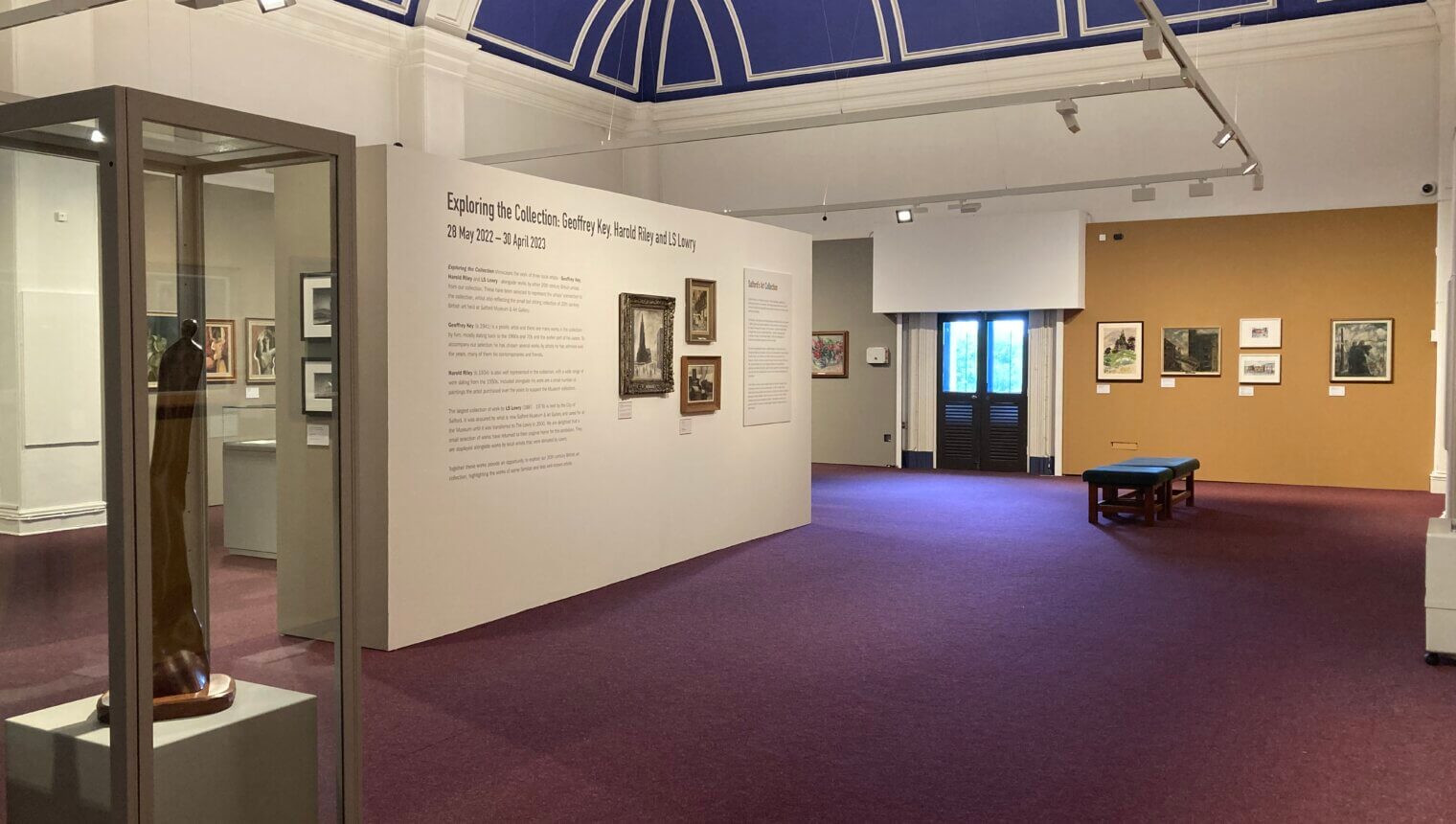 Yellow and white walls with framed paintings on them.