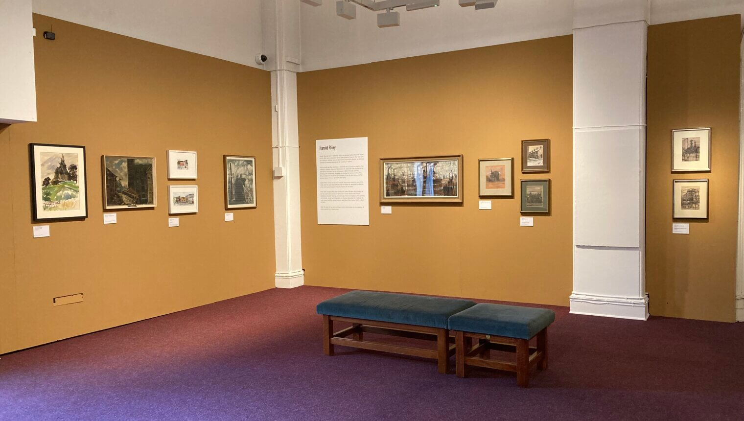 Yellow walls with framed paintings hanging on them.