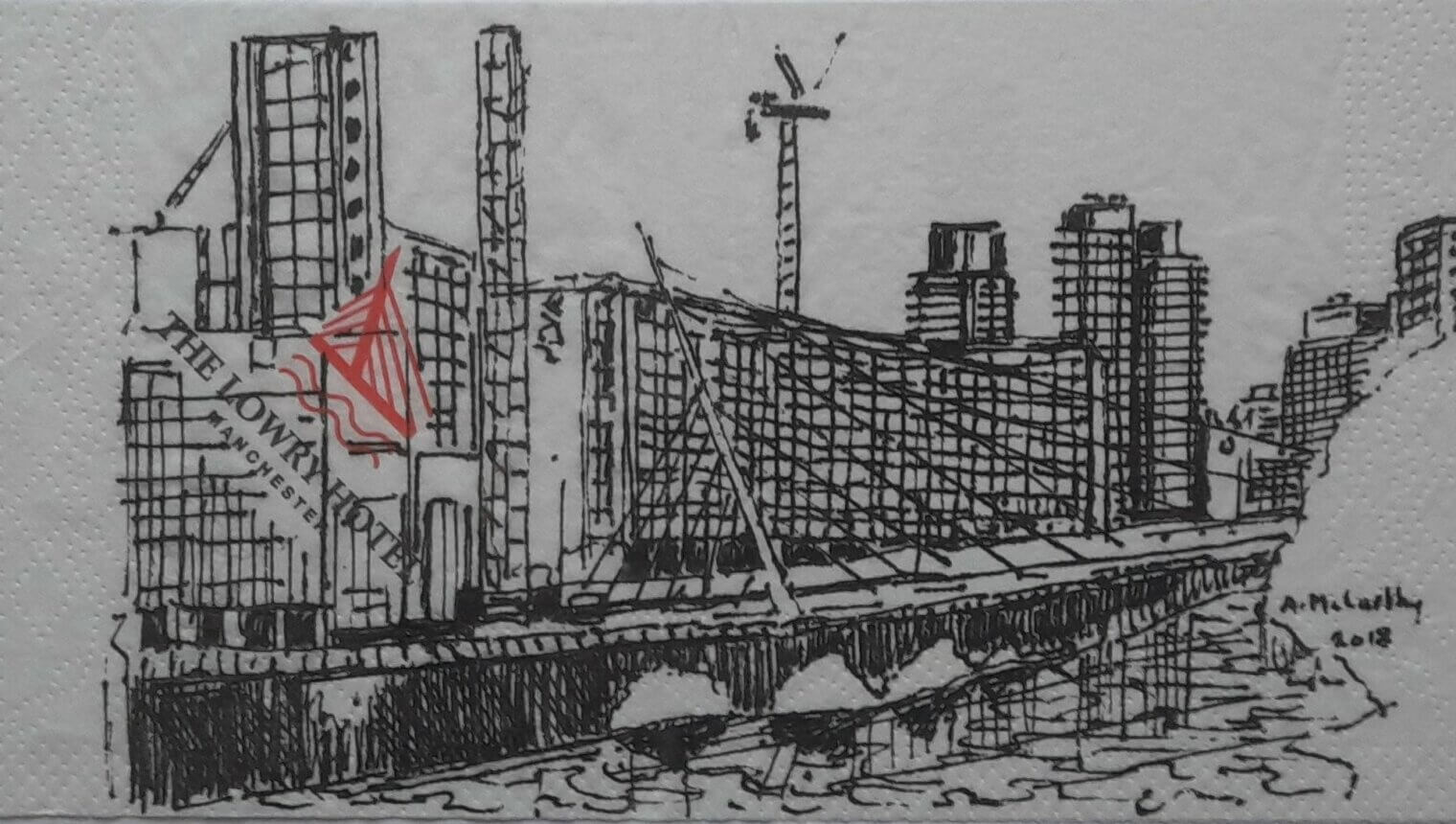 A painting on a napkin showing skyscrapers by the side of a river.