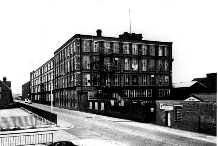 A black and white photograph of a chunky brick office block.