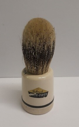 A brown bristle brush with a short cream handle. The handle has the words Culmak 'Fifty-Fifty' written on it.