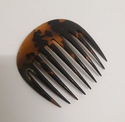 A brown and black curved hair ornament with long combs for pushing back hair.