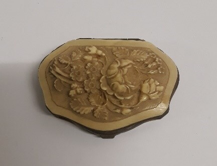 An ivory purse carved with a flower pattern.