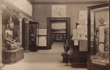A room with a statue of Buddha and other artefacts, like a suit of armour, in display cases.