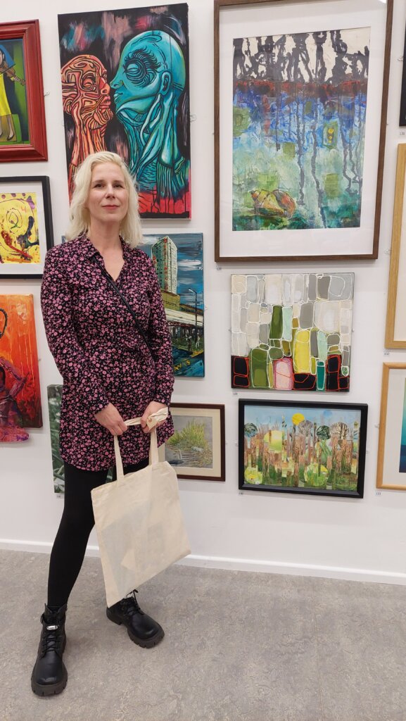 Artist standing next to winning artwork