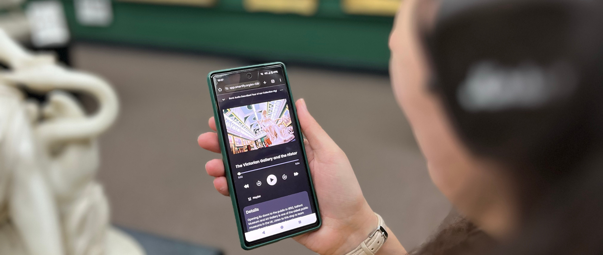 Person holding phone in gallery