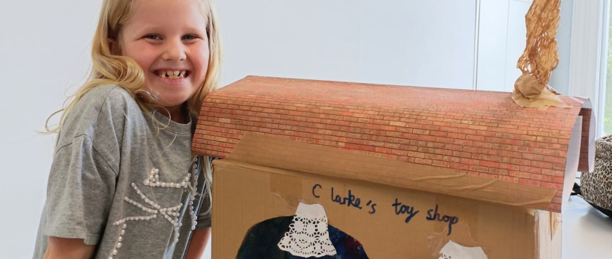 Child with cardboard creation