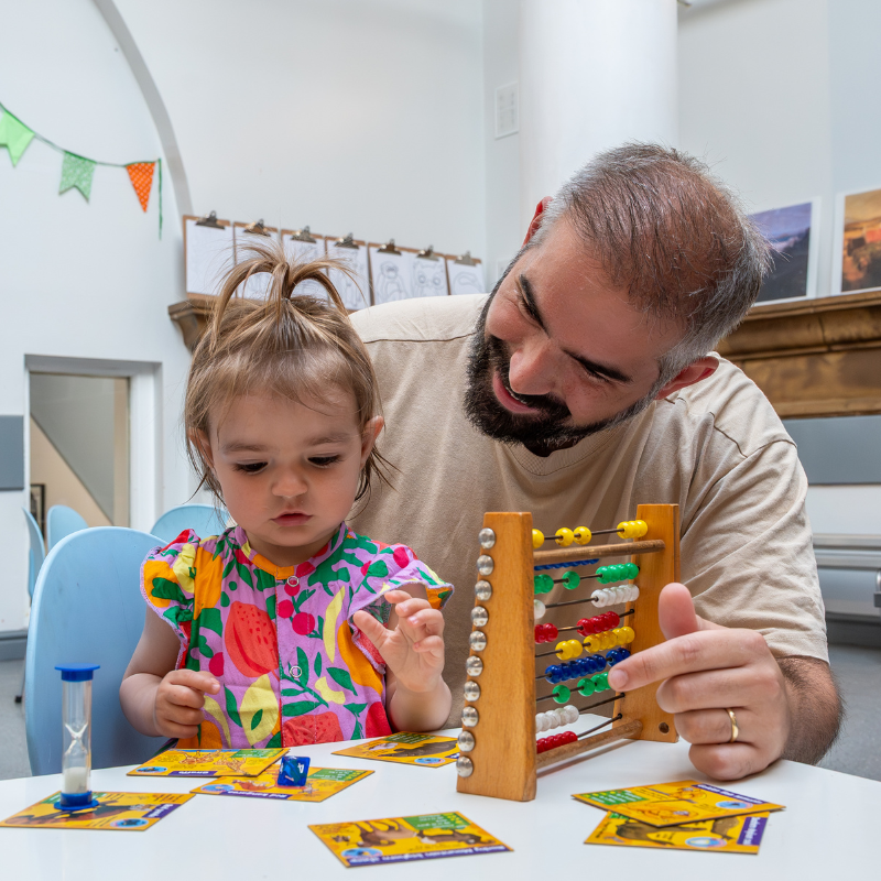 Man and young child playing with toys