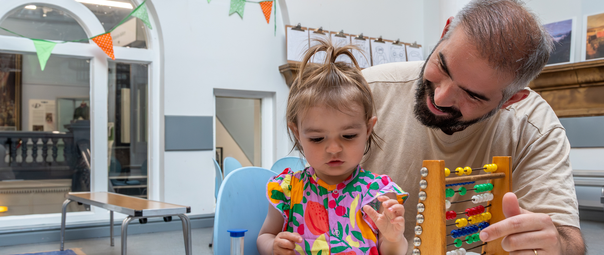 Man and young child playing with toys